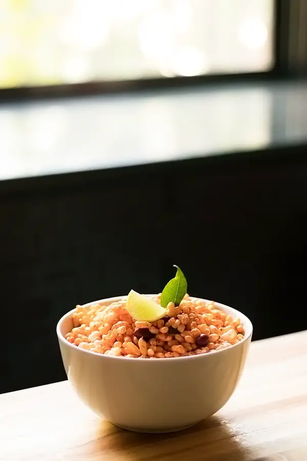 Kolhapuri Bhadang in a bowl, garnished with a lemon wedge and curry leaf