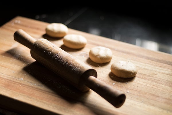 Rolling pin and dough balls on a wooden board