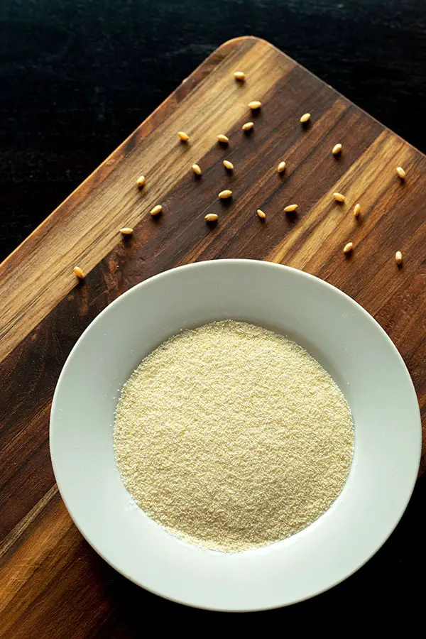 Rava in a plate with some wheat grains on a wooden board