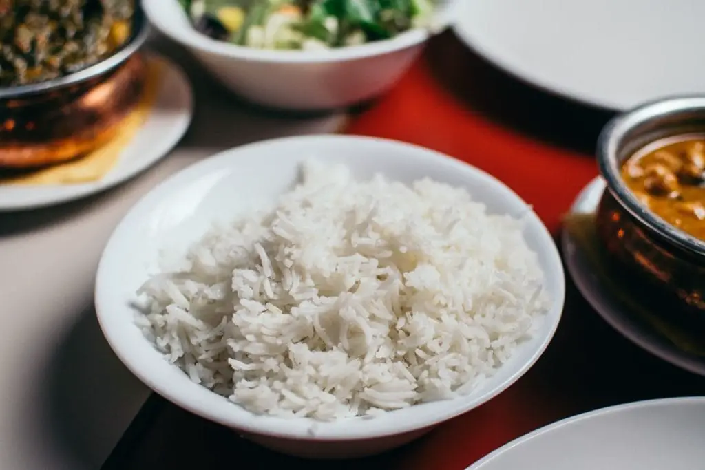 cooked basmati rice in a plate along with different Indian curries